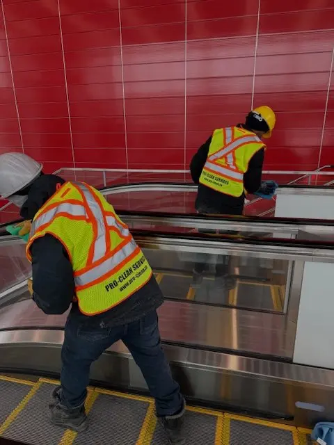 Pro-Clean workers cleaning an escalator and its railings